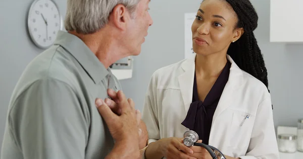 Black woman doctor listening to elderly patient breathing — Stock Photo, Image