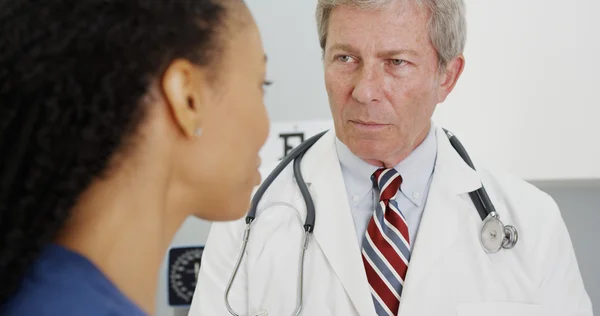 Zwarte vrouw patiënt praten met haar arts — Stockfoto