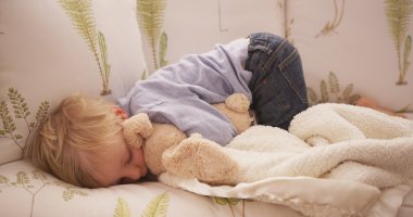 Sevimli küçük beyaz çocuk bir koltukta yalan 