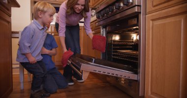 Güzel annesi için çerezleri fırın fırın kapağı açar