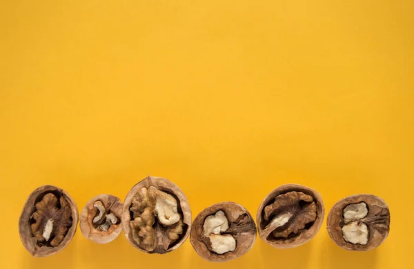 Hardal arkaplanda ceviz. Cevizler bir bütün ve aç.