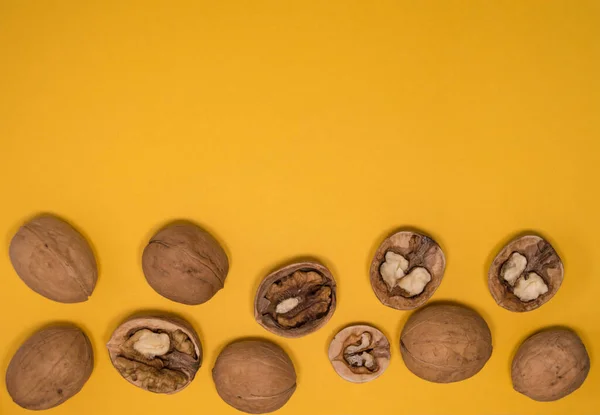 Hardal arkaplanda ceviz. Cevizler bir bütün ve aç.