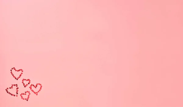 Pembe arka planda parıldayan kırmızı kalp. Pankart. Sevgililer Günü, Uluslararası Kadınlar Günü