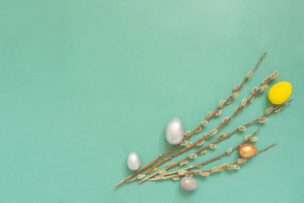 Yeşil arka planda söğüt dalları olan renkli paskalya yumurtaları. Metin için boş alanı olan Paskalya kartı