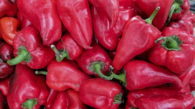 Süpermarketteki tezgahın üzerine kırmızı dolmalık biber koy. Bir yığın kırmızı biber.