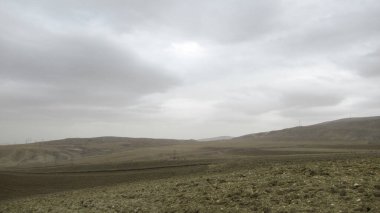 Ana yolun kenarındaki, sade sarı-gri manzaralı tarım arazisi. Tarla ekimi ekime hazır.