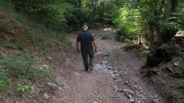 Orta yaşlı bekar bir adam vahşi bir ormanda tek başına yürüyor.