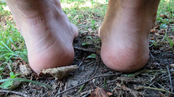 Close up of a single male, man bare foot touching to the soil.