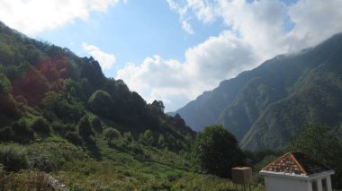 Büyük yeşil Kafkas dağ ormanlarının ve beyaz bulutlu mavi gökyüzünün güzel manzarası.