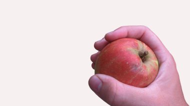 Kırmızı elma tutan bir erkeğin yakın çekimi.