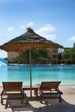 şezlong ve şemsiye havuzun çevresindeki