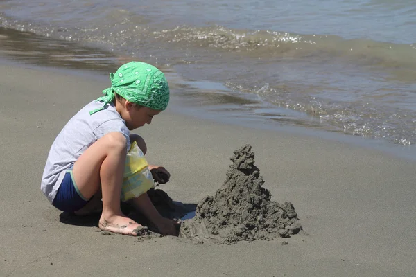 Chlapec je založena hrad z písku, — Stock fotografie