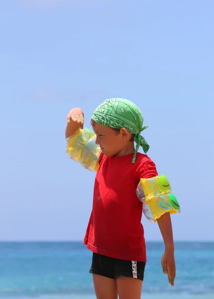 Junge am Strand blickt in die Ferne — Stockfoto