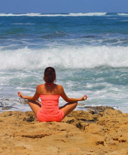 Belle fille sur la plage assise en position lotus — Photo