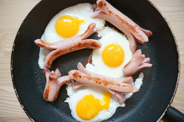 Fried eggs with sausage in a pan — Stock Photo, Image
