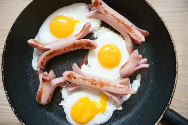 Fried eggs with sausage in a pan — Stock Photo, Image