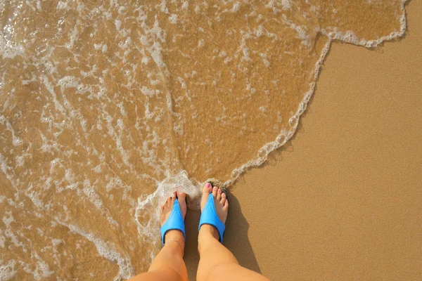 Foot in flip flops on the beach — Stock Photo, Image