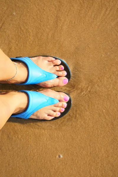 Pé feminino em chinelos na praia — Fotografia de Stock