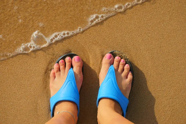 Pé feminino em chinelos na praia — Fotografia de Stock