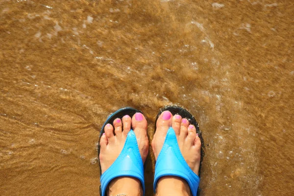 Female foot in flip flops on the beach — Stock Photo, Image