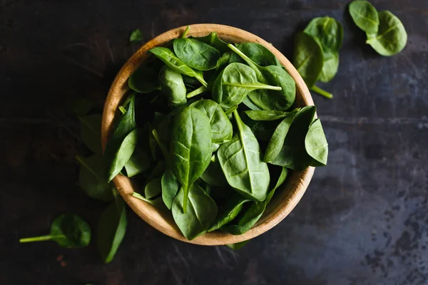 Fresh spinach leaves in a wooden bowl — Stock Photo, Image