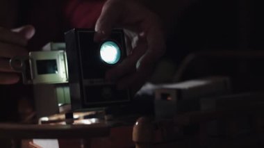 Adam fotoğraf slayt projektörde gösterir.