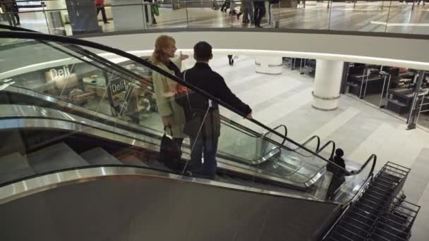 Two people down the escalator in the shopping centre Stockmann in St. Petersburg — Stock Video