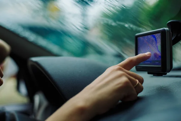 Mujer mira un navegador GPS en el coche — Foto de Stock