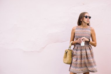 Zarif genç kadın kahve ile hafif pembe duvara