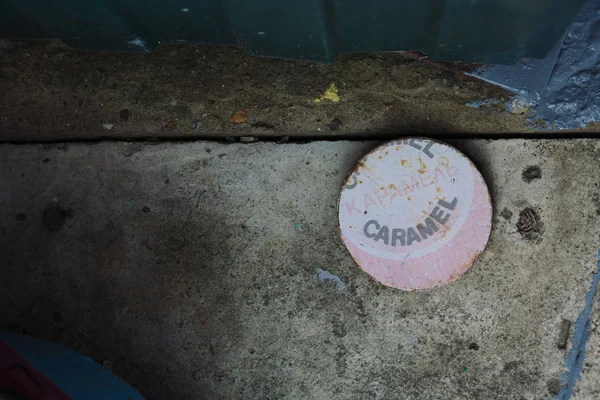 Flat round object with caramel word on cement ground