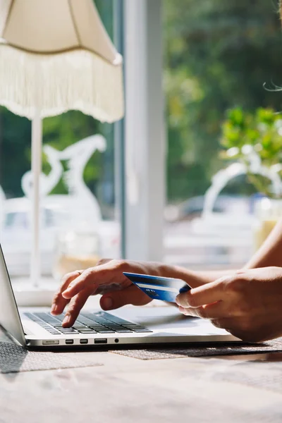 Mujer usando el ordenador portátil con tarjeta de crédito en la mano — Foto de Stock