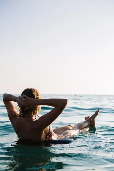 Rückansicht einer entspannten Frau, die auf einem aufblasbaren Ring schwimmt — Stockfoto