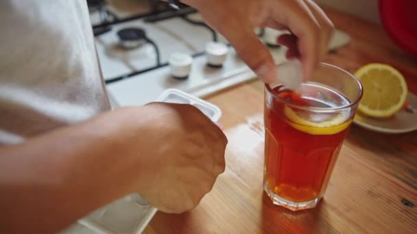 Man in the kitchen preparing tea with ice — Stock Video