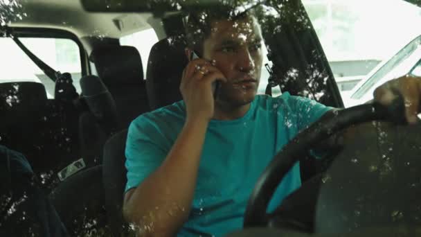 Mężczyzna rozmawia przez telefon komórkowy w samochodzie zaparkowanym. — Wideo stockowe