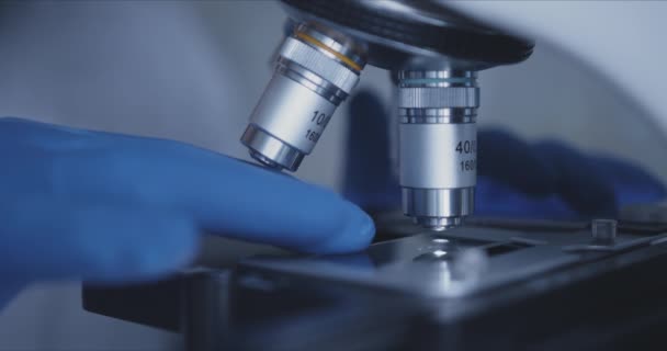 Muestra de diapositiva y microscopio con lente metálica en laboratorio. — Vídeo de stock