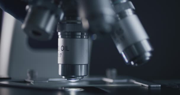 Sample slide and microscope with metal lens at laboratory. — Stock Video