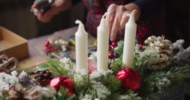 Девушка-флористка готовит красивую рождественскую корзину — стоковое видео