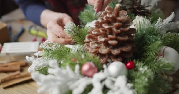 Blomsterhandlare gör julkorgen med röda bär, gran grenar och barrträd — Stockvideo
