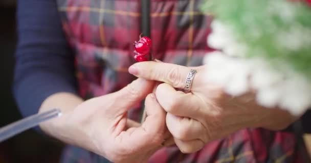Флорист робить прикрасу на Різдво червоних ягід і гілок — стокове відео