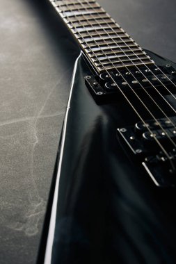 Koyu grunge arka planında siyah V biçimli elektro gitar.