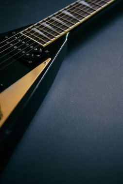 Koyu grunge arka planında siyah V biçimli elektro gitar.