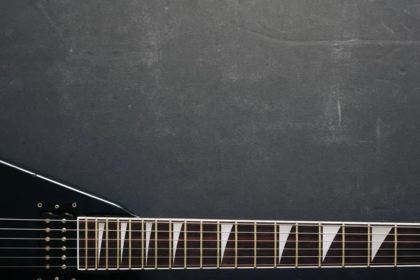 Koyu grunge arka planında siyah V biçimli elektro gitar.