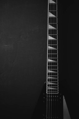 Koyu grunge arka planında siyah V biçimli elektro gitar.
