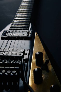 Koyu grunge arka planında siyah V biçimli elektro gitar.