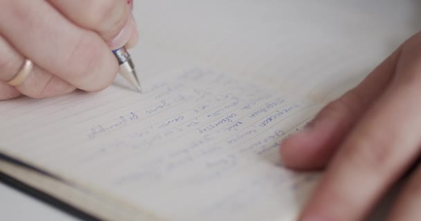 El hombre escribe algo en su diario — Vídeos de Stock