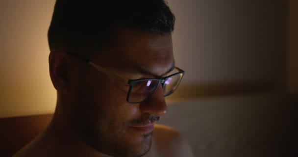 Fiatal férfi az ágyban nézi a képernyőn az okostelefon. — Stock videók