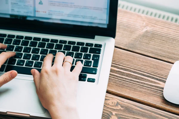 Femme travaillant avec un ordinateur portable placé sur un bureau en bois — Photo