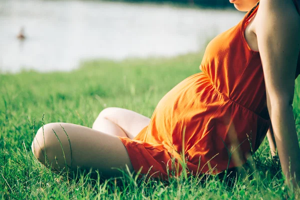 Pregnant woman, holding in hands bouquet of daisy 