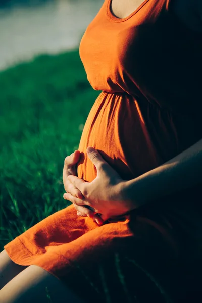 Schwangere hält Strauß Gänseblümchen in den Händen — Stockfoto