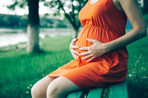 Pregnant woman, holding in hands bouquet of daisy 
